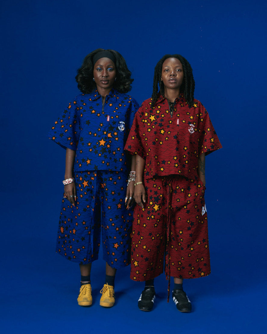 Two individuals wearing matching African outfits with star patterns on a blue background