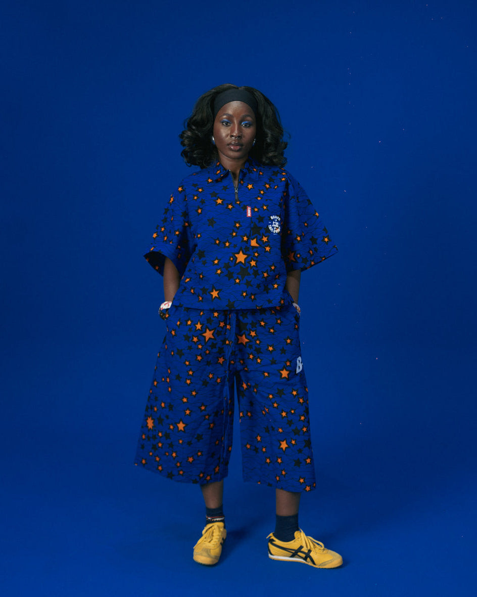 Person wearing a African blue outfit with star patterns on a blue background
